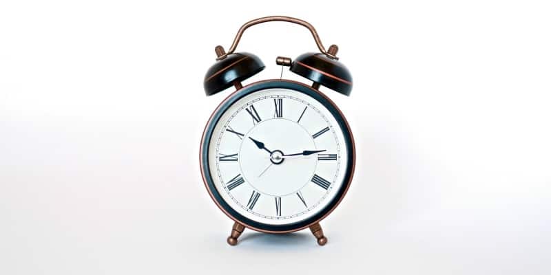 Old fashioned alarm clock on white background