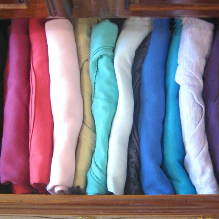 t-shirts neatly folded in drawer and organized by color