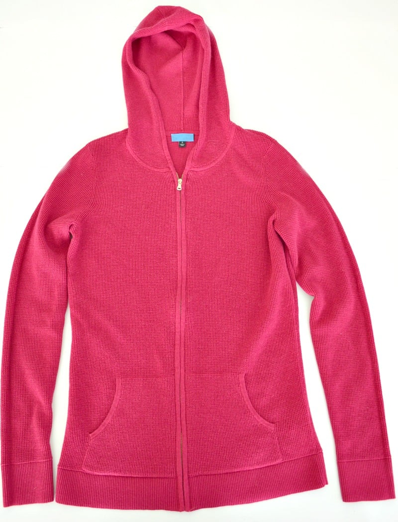 Pink hoodie laid out neatly on a white background.