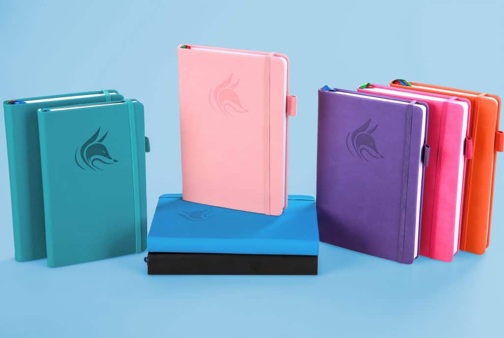 brightly colored Clever Fox planners on a blue background.