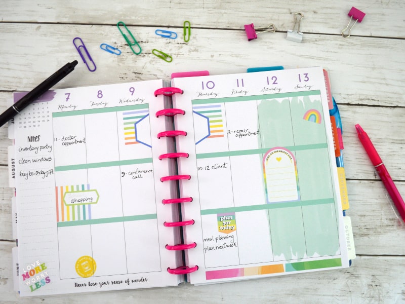 Overhead view of an open Happy Planner with colorful stickers.