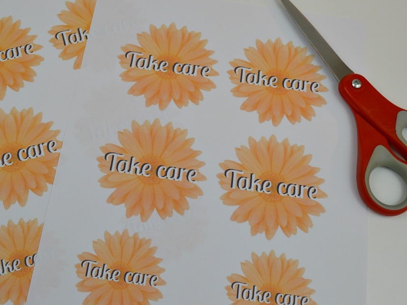 sheets of printed "take care" notes with pair of scissors