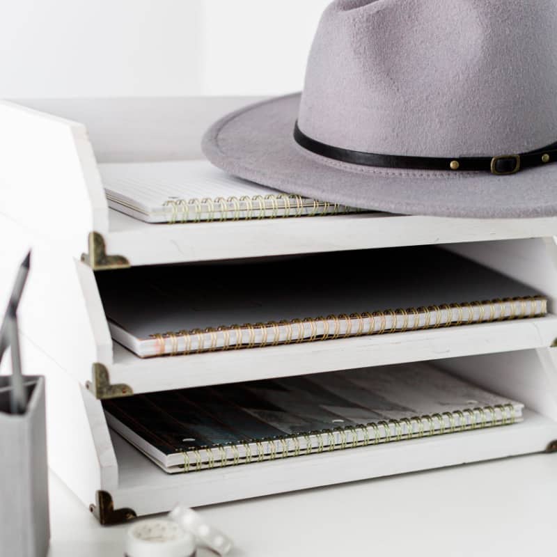 white three-shelf paper tray with grey hat on top.