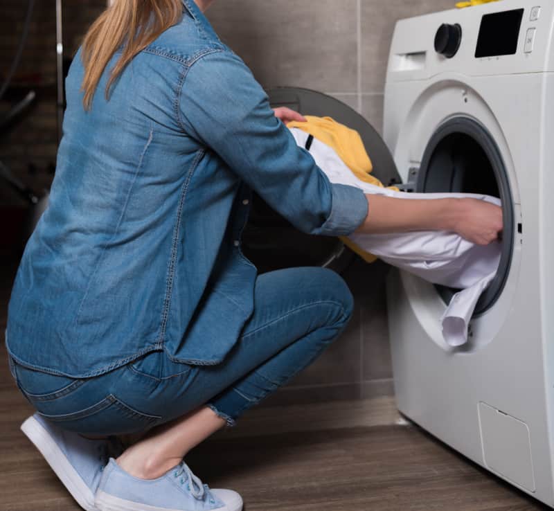 woman taking laundry out of a clothes dryer.