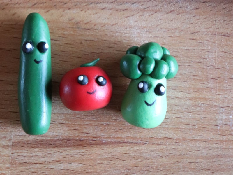 2 small clay Veggie Tales Characters on wood table