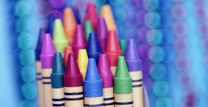 close up of brightly colored crayons on blue background