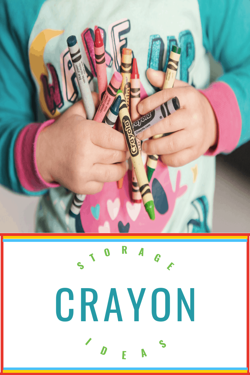 young child holding handfuls of crayons