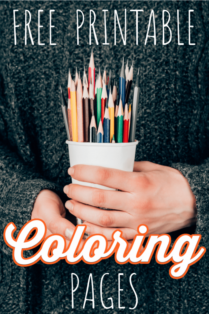hands holding a white cup of colored pencils