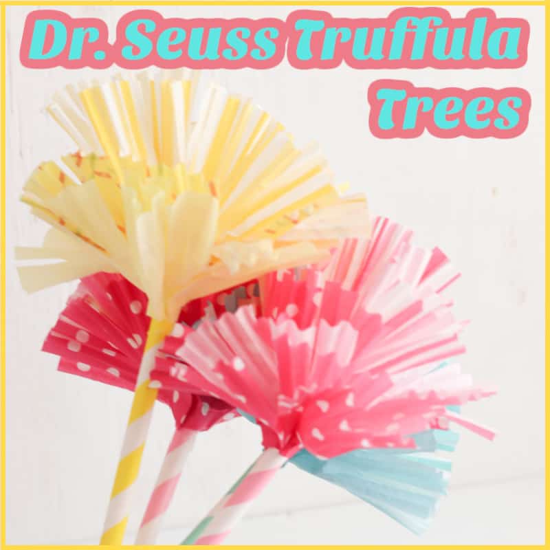 yellow, pink and blue paper flowers on striped stem with white ribbon tying them together and tilted to the right with title text reading Dr. Seuss Truffula Trees