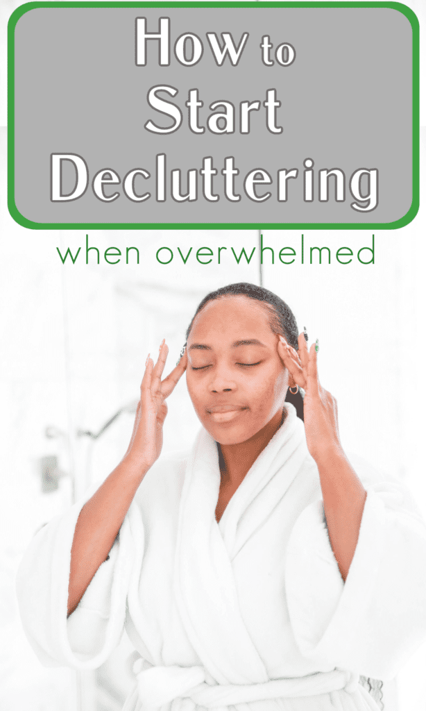 black woman in white bathrobe rubbing her temples with eyes closed