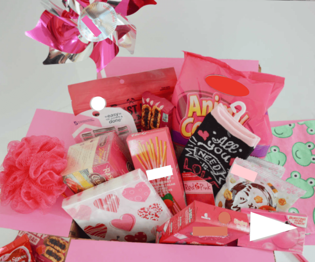 close up overhead view of pink box filled with pink themed gift items