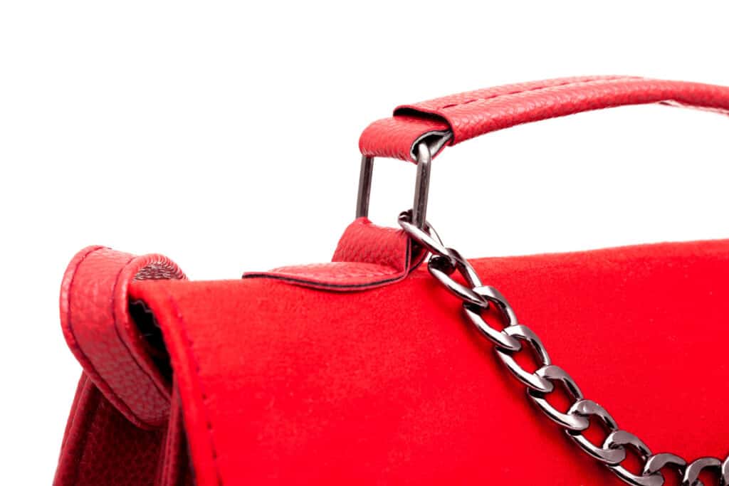 close up of chain strap and handle of red bag.