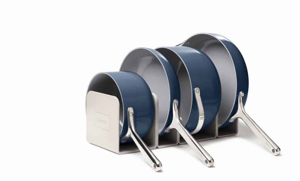 4 navy Caraway brand pots stored vertically with white background.