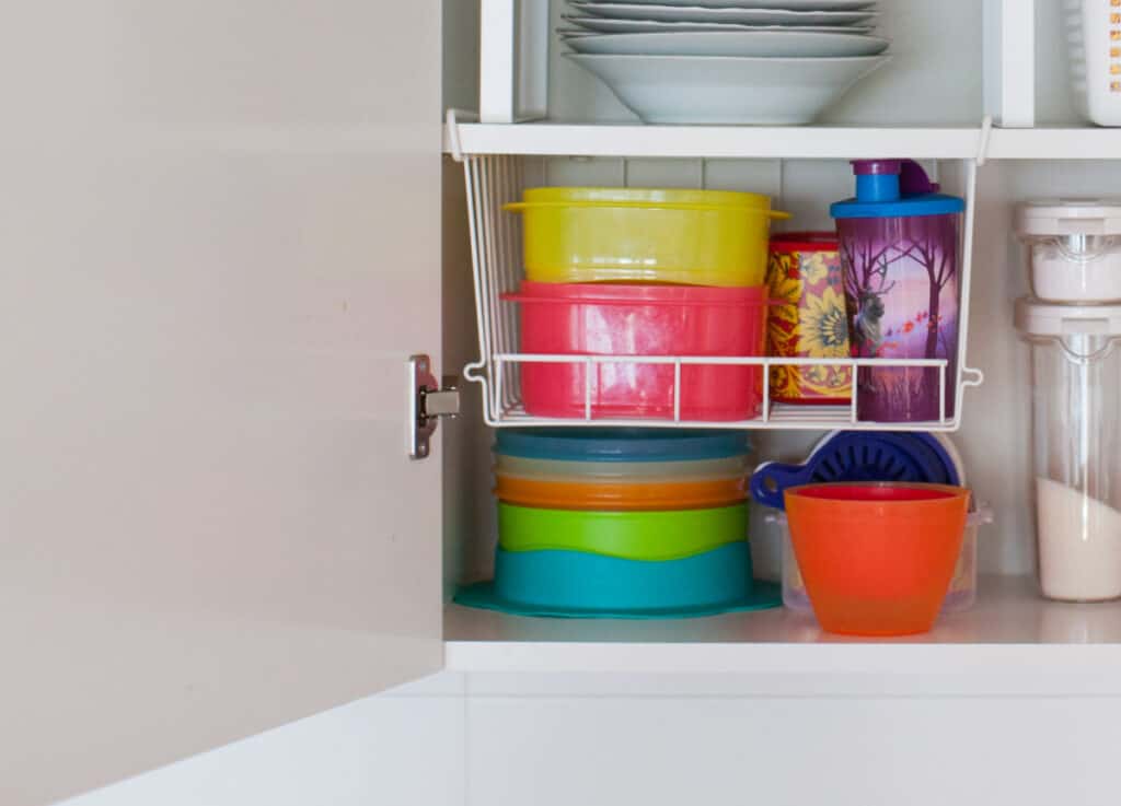 brightly colored bowls in kitchen cabinet.