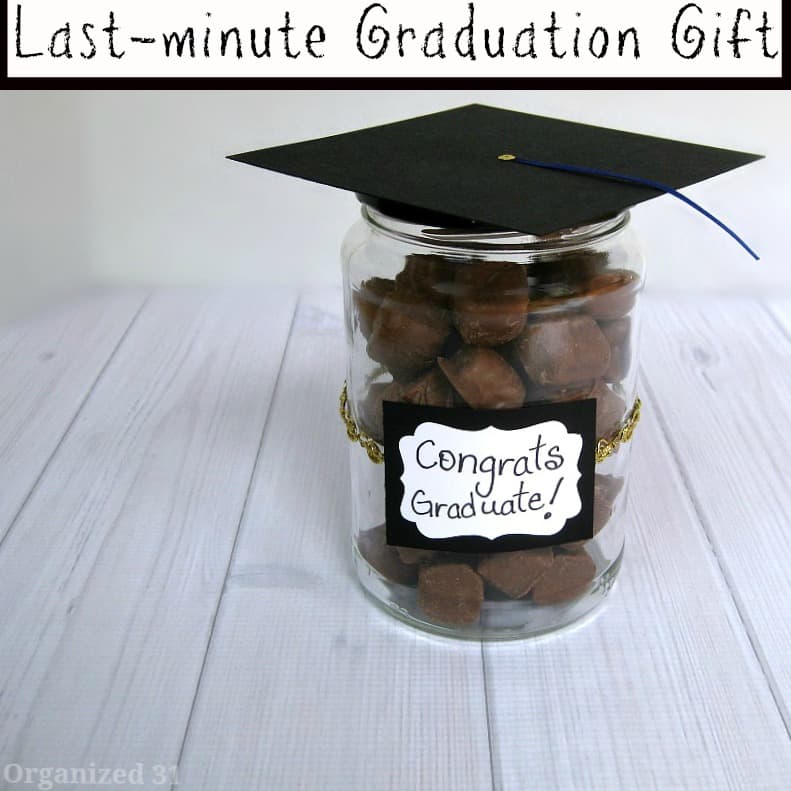 glass jar decorated with graduation cap and filled with chocolate candy.