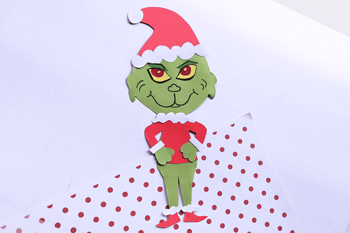 DIY Grinch craft from paper on red and white polka dot background.