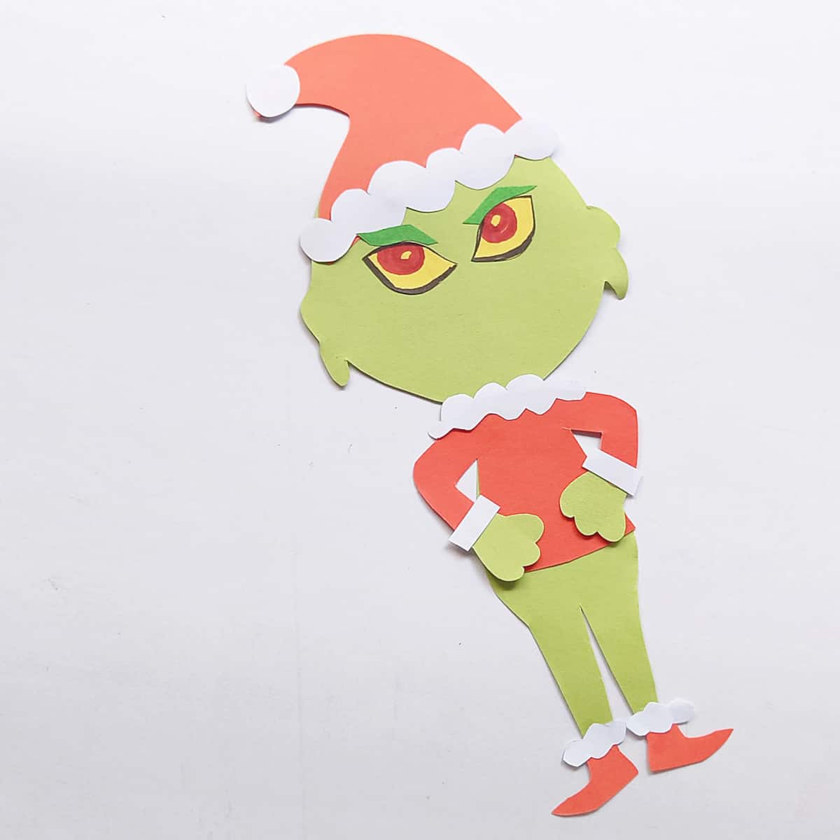 Green Grinch paper figure with eyes attached, but no face.
