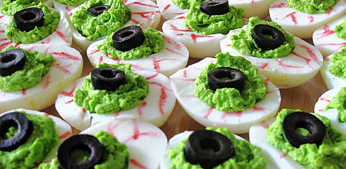 overhead view of deviled eggs decorated to look like scary eyeballs.