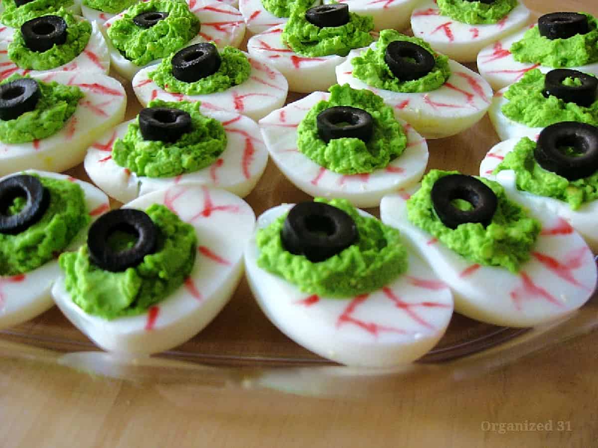 close up of decorated scary eyeball deviled eggs on plate.