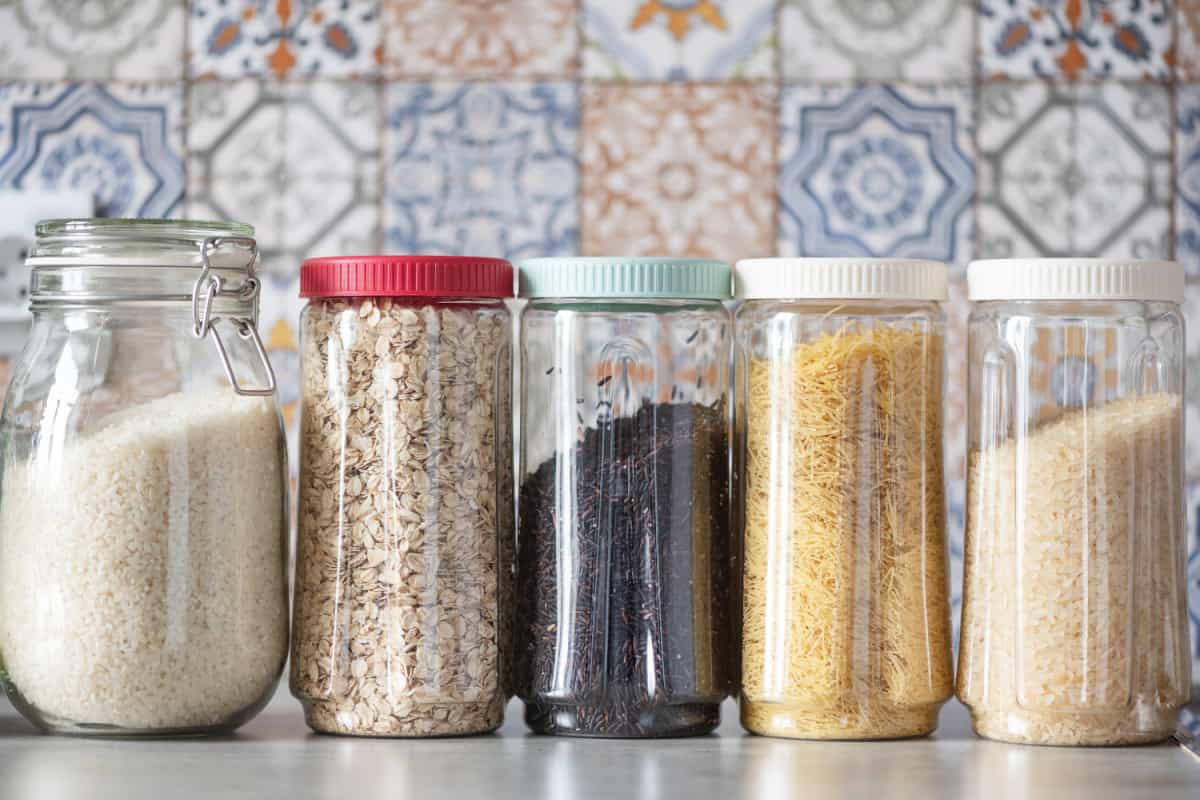 Different types of rice in glass jars on a counter.